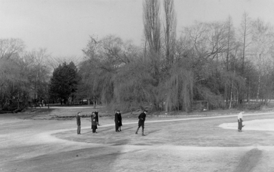 221097 Gezicht op de bevroren vijver van het Wilhelminapark te Utrecht, met enkele schaatsers.